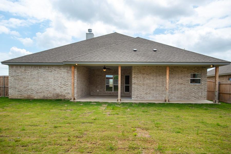 Back of house featuring brick siding, a patio, a chimney, a ceiling fan, and roof with shingles Back of house featuring brick siding, a patio, a chimney, a ceiling fan, and roof with shingles
