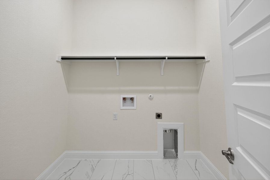 Washroom featuring gas dryer hookup, hookup for an electric dryer, washer hookup, and marble finish flooring Washroom featuring gas dryer hookup, hookup for an electric dryer, washer hookup, and marble finish flooring