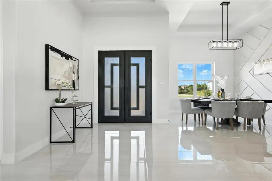 Foyer entrance featuring french doors, a raised ceiling, and a towering ceiling Foyer entrance featuring french doors, a raised ceiling, and a towering ceiling