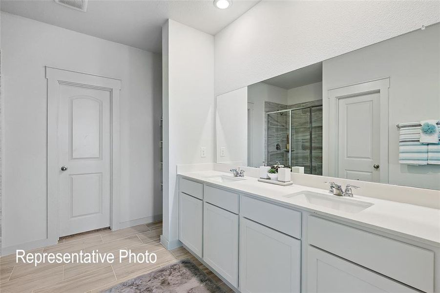 Double vanity with undermount sinks, chrome faucets, and white cabinetry