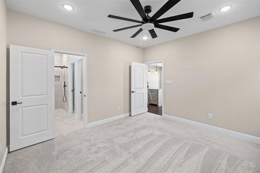 Spacious room with light-toned walls and plush gray carpeting