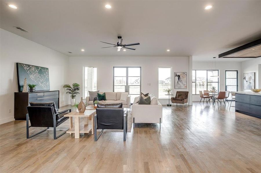 Living area with light wood-type flooring, visible vents, and recessed lighting