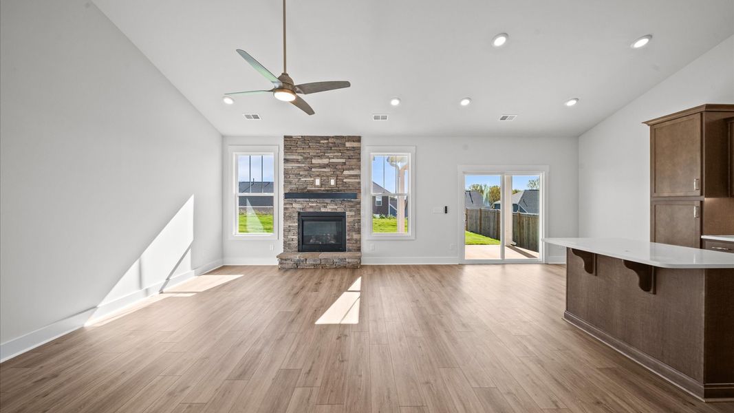 Dramatic two-story family room with fireplace, accomplished detailing, and seamless indoor-outdoor connection
