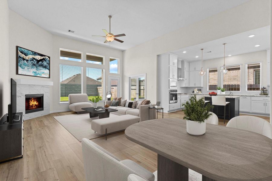 Expansive family room with soaring ceilings, large windows for natural light, and a cozy gas fireplace open to the kitchen.  What a Wow Factor! *Virtually Staged*