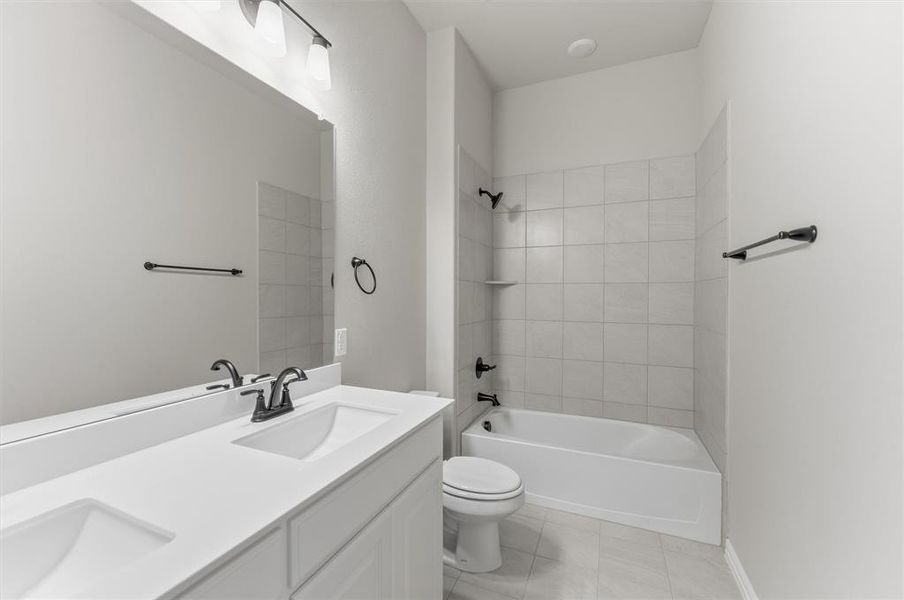 Bathroom with double vanity, shower / bathtub combination, and light tile patterned floors Bathroom with double vanity, shower / bathtub combination, and light tile patterned floors