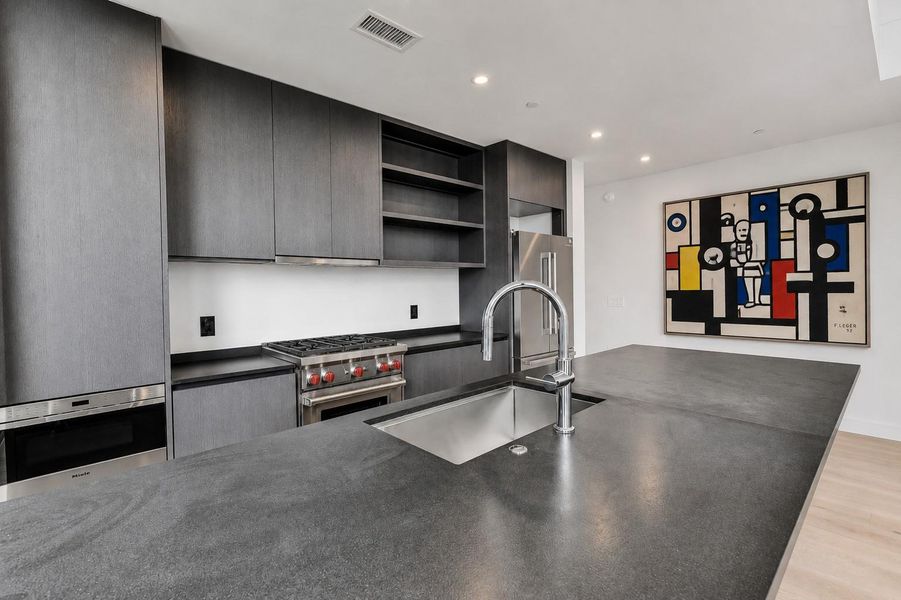 Sleek dark cabinetry paired with stone countertops defines this modern culinary workspace. Sleek dark cabinetry paired with stone countertops defines this modern culinary workspace.