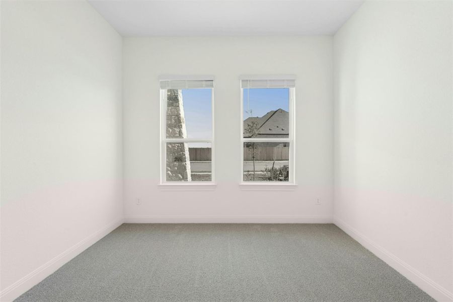Spare room featuring carpet floors and baseboards