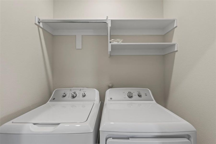 Laundry area featuring washer and dryer and a textured wall