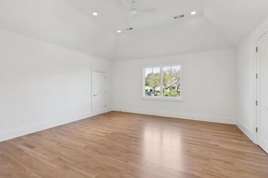Spare room with light wood-style flooring, ceiling fan, vaulted ceiling, and recessed lighting