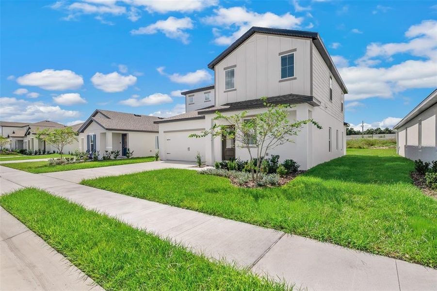 Front exterior of a new home in Peach Crossings, Winter Haven, FL, highlighting curb appeal (Image 18).