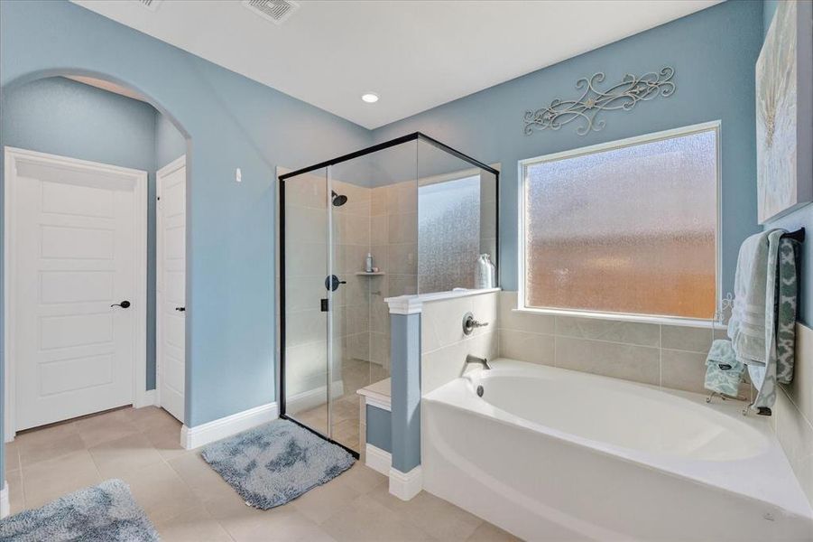 Bathroom featuring a bath, a stall shower, and tile patterned flooring Bathroom featuring a bath, a stall shower, and tile patterned flooring