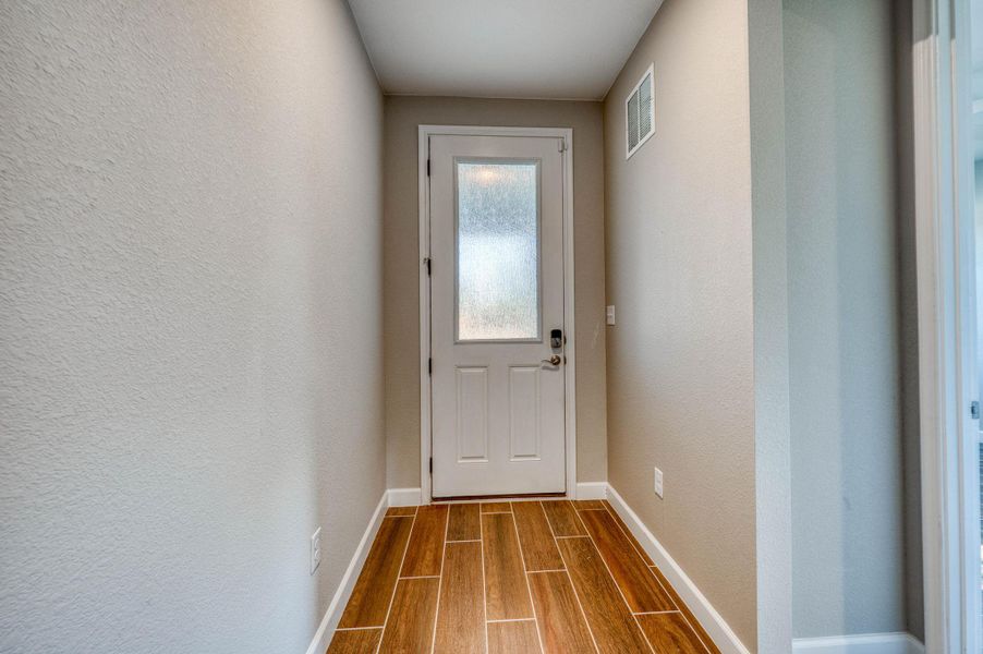 A welcoming entryway features handsome plank flooring and a modern door with textured glass inlay. A welcoming entryway features handsome plank flooring and a modern door with textured glass inlay.