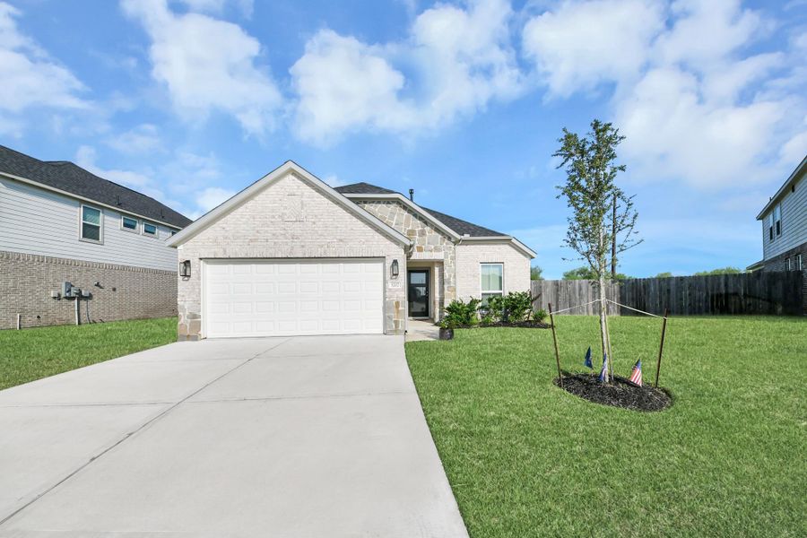 Clean architectural lines and bright curb appeal framed by fresh green turf and clear Fort Bend County skies.