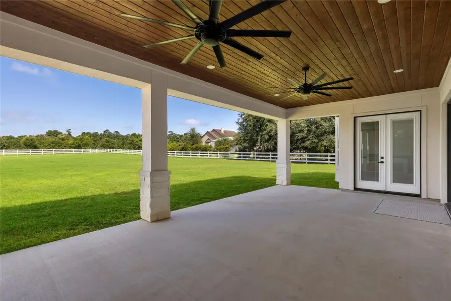 This in another great angle on the patio looking towards the French doors leading to the Primary bedroom. You can see the entire 1.55 acres is fenced. The yard has sprinklers from the aerobic sewer system to keep your grass green and healthy. This in another great angle on the patio looking towards the French doors leading to the Primary bedroom. You can see the entire 1.55 acres is fenced. The yard has sprinklers from the aerobic sewer system to keep your grass green and healthy.