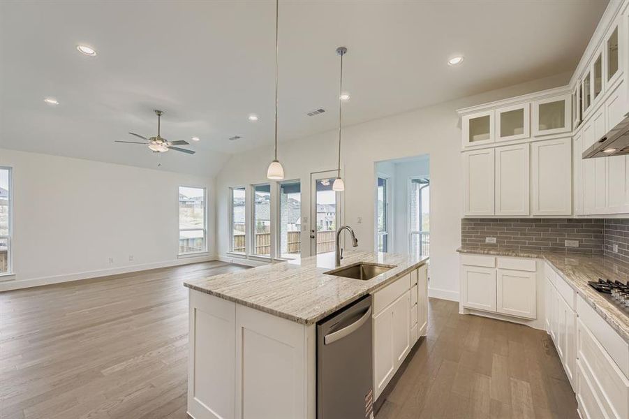 Kitchen featuring white cabinetry, decorative backsplash, pendant lighting, recessed lighting, and stainless steel dishwasher Kitchen featuring white cabinetry, decorative backsplash, pendant lighting, recessed lighting, and stainless steel dishwasher