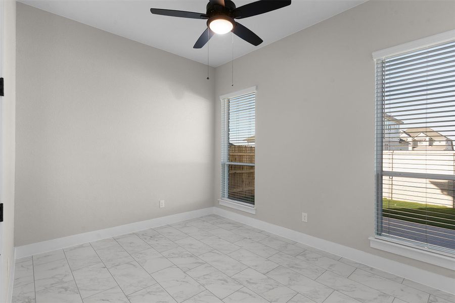 Spare room with a ceiling fan and light marble finish floors