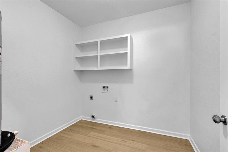 Washroom with light wood finished floors, hookup for a washing machine, and hookup for an electric dryer Washroom with light wood finished floors, hookup for a washing machine, and hookup for an electric dryer