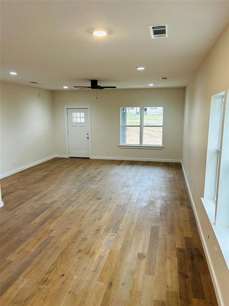 Living room with ceiling fan and light hardwood / wood-style floors