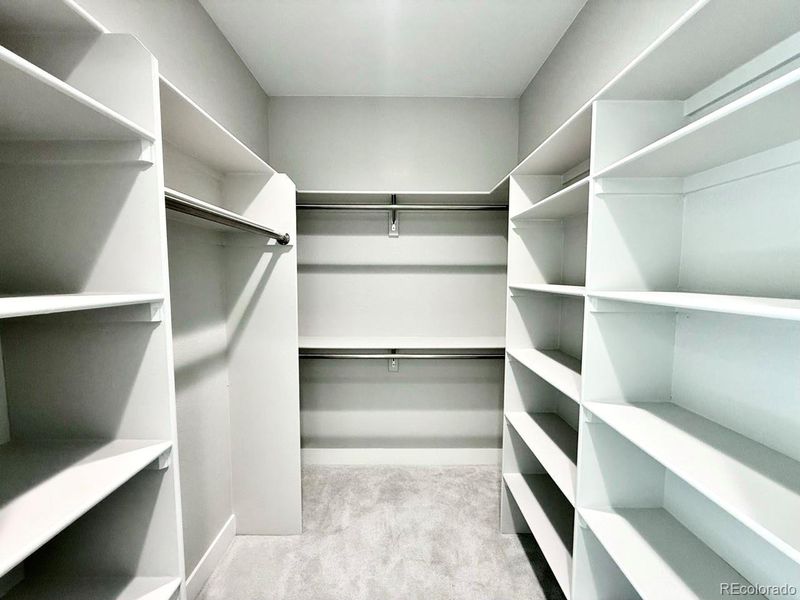 Walk-in closet with wooden shelving. Walk-in closet with wooden shelving.