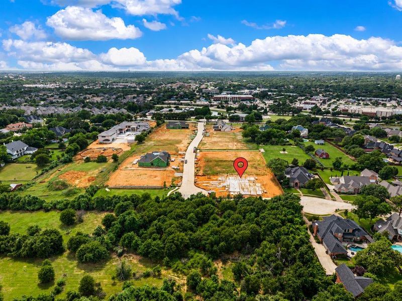 Generous lot with a partial foundation and surrounding cleared land, set among established neighborhoods and green spaces