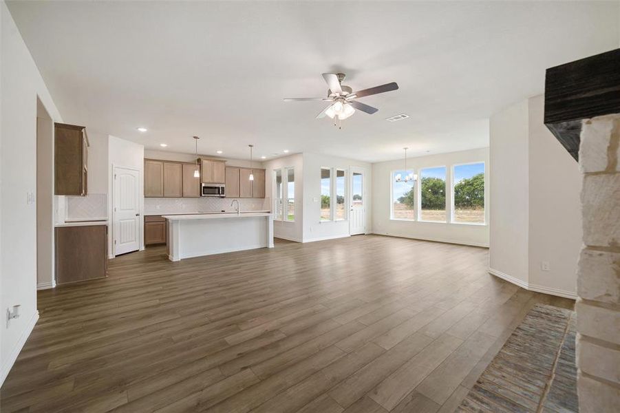 Unfurnished living room featuring dark wood-style flooring, a chandelier, ceiling fan, and recessed lighting