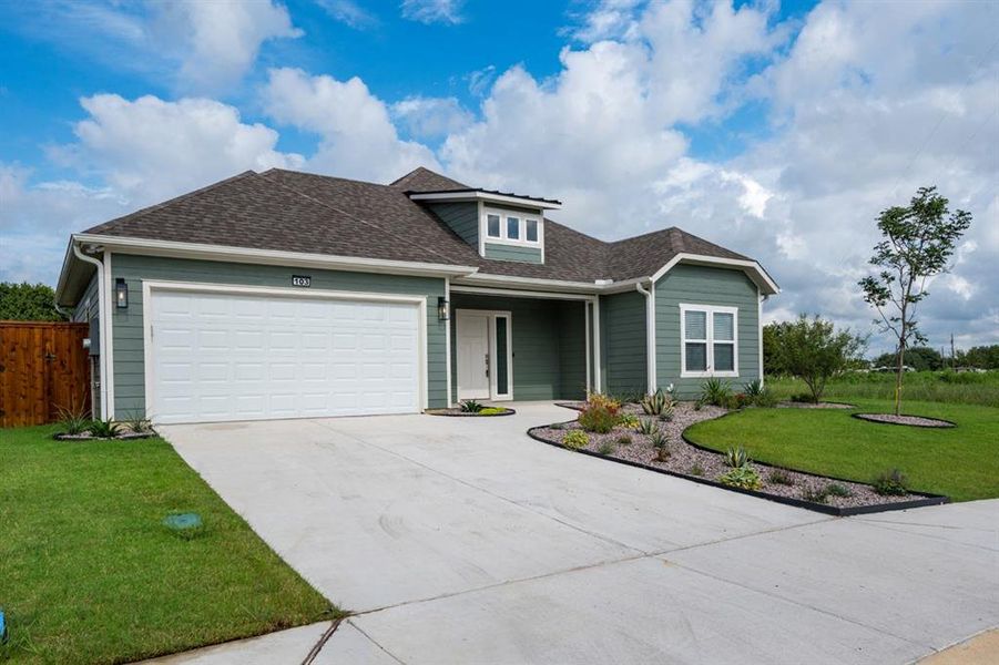 View of front of house with a garage and a front lawn