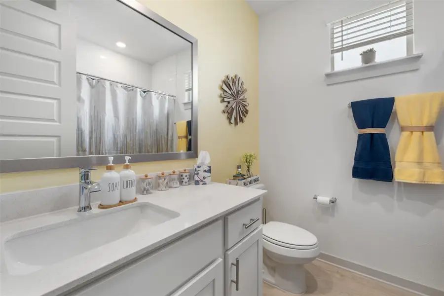 Bathroom featuring vanity, light wood-style flooring, and a shower with curtain Bathroom featuring vanity, light wood-style flooring, and a shower with curtain
