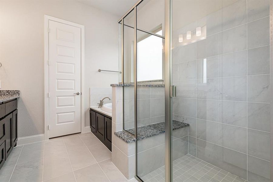 Bathroom with a shower with door, vanity, and tile patterned flooring