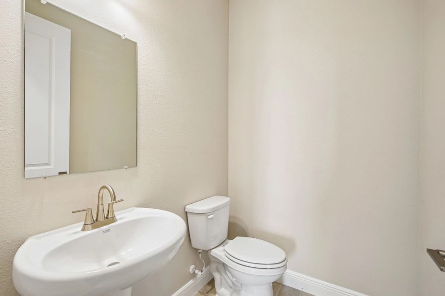 Half bathroom located off the foyer perfect for guests