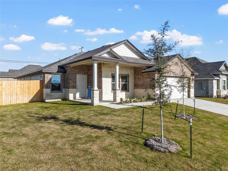View of front facade with concrete driveway, covered porch, brick siding, and a garage