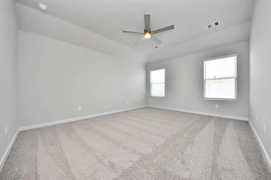 Escape to tranquility in this spacious primary room, adorned with plush carpeting and bathed in the soothing hues of warm paint colors, creating a cozy retreat for relaxation. Sample photo of completed home with similar floor plan. Actual colors and selections may vary. Escape to tranquility in this spacious primary room, adorned with plush carpeting and bathed in the soothing hues of warm paint colors, creating a cozy retreat for relaxation. Sample photo of completed home with similar floor plan. Actual colors and selections may vary.