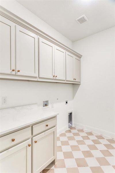 Washroom featuring hookup for an electric dryer, hookup for a washing machine, hookup for a gas dryer, cabinet space, and light floors Washroom featuring hookup for an electric dryer, hookup for a washing machine, hookup for a gas dryer, cabinet space, and light floors