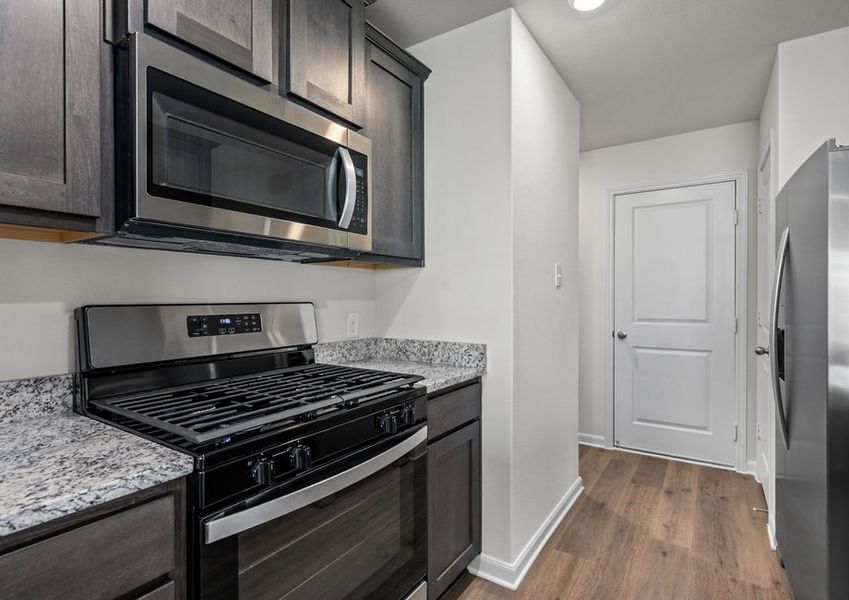The kitchen has designer wood cabinetry.