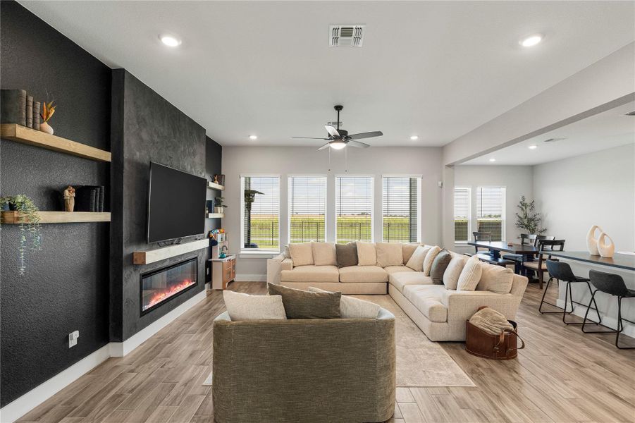 An inviting family room unfolds with natural light and a chic fireplace, creating an ideal setting for relaxation. An inviting family room unfolds with natural light and a chic fireplace, creating an ideal setting for relaxation.