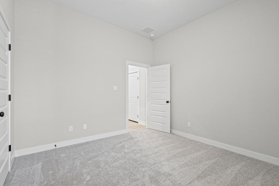 Spare room featuring light colored carpet and baseboards