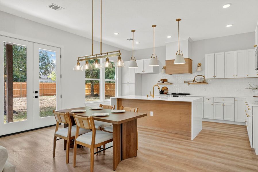 Kitchen featuring light wood-type flooring, light stone counters, tasteful backsplash, white cabinets, and recessed lighting