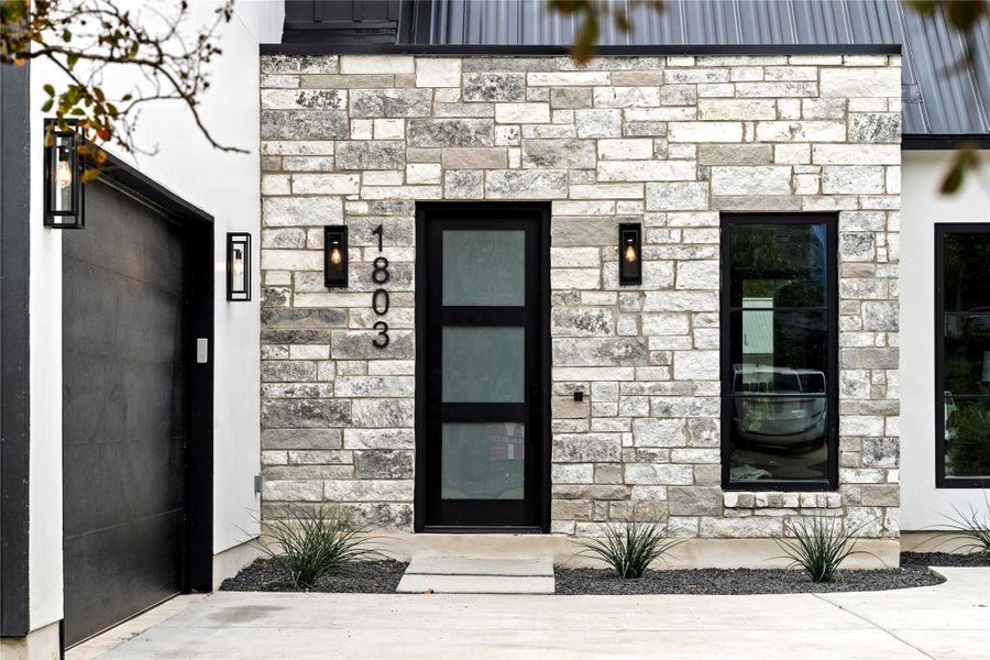 View of exterior entry featuring stone siding and elevator