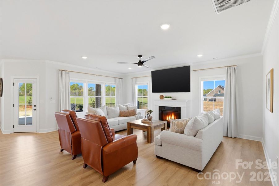 This light-filled living space features an open-concept design with warm wood floors, expansive windows, and a seamless flow that creates an inviting and comfortable atmosphere for everyday living and entertaining.