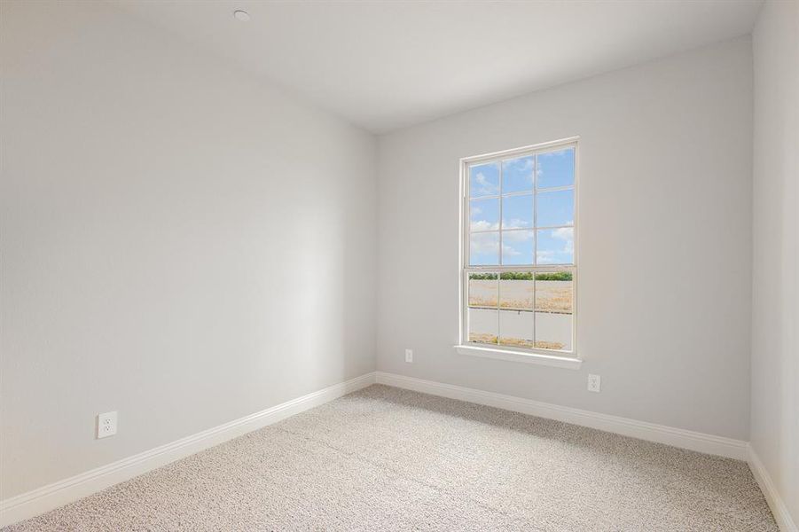 Spare room with carpet and baseboards