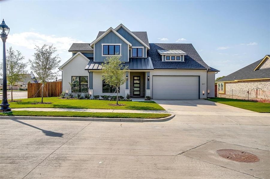 View of front facade featuring a front yard and a garage