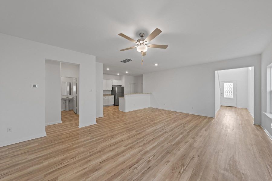 Unfurnished living room with light wood finished floors, a ceiling fan, and recessed lighting