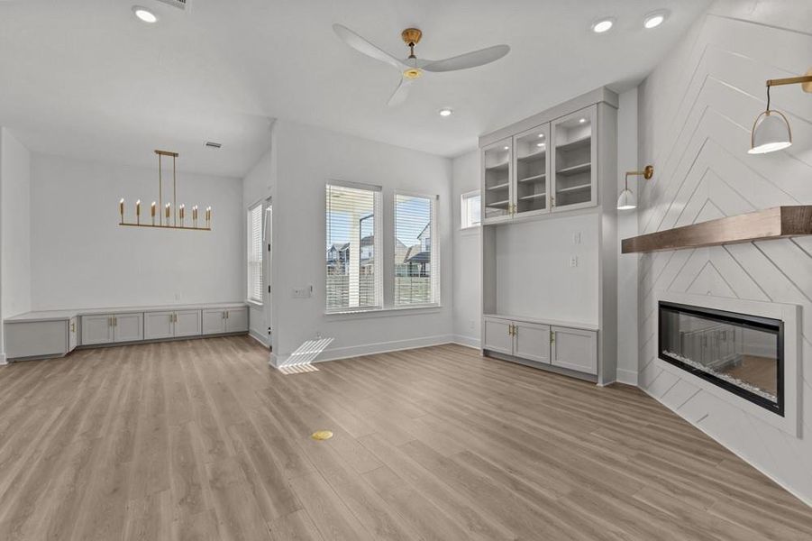 Unfurnished living room with light wood-style flooring, a fireplace, a ceiling fan, and recessed lighting