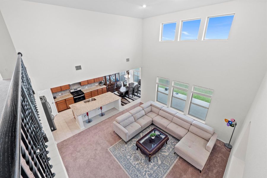 Spacious open-concept living area featuring a two-story ceiling and multiple windows