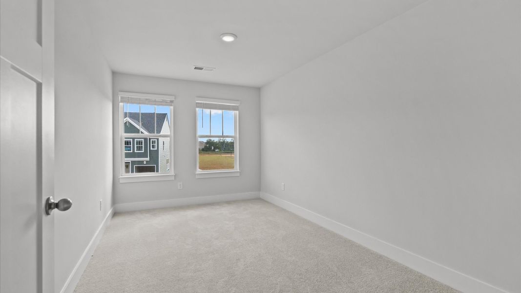 Inviting bedroom with tasteful finishes and large windows that create a fresh, open ambiance