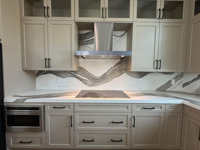 Appliances shown are a 36" Induction cooktop, ventilation hood, and a microwave drawer.