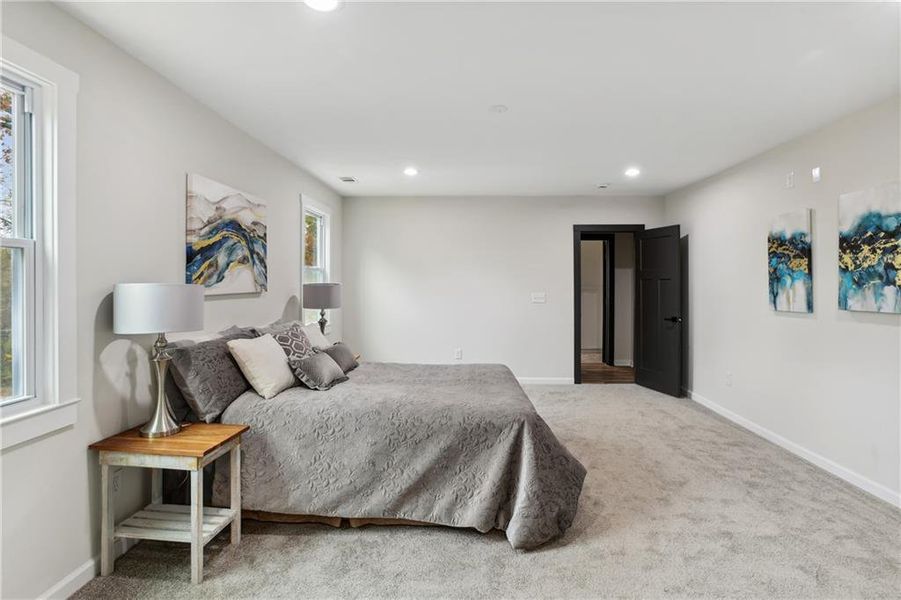 Carpeted bedroom featuring multiple windows