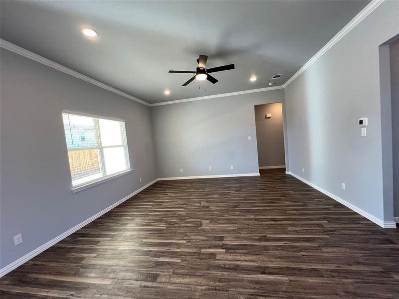 Spare room with crown molding, dark hardwood / wood-style flooring, and ceiling fan