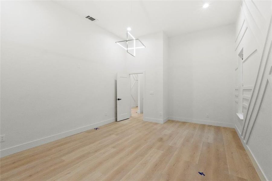 Washroom featuring a high ceiling and light hardwood / wood-style flooring