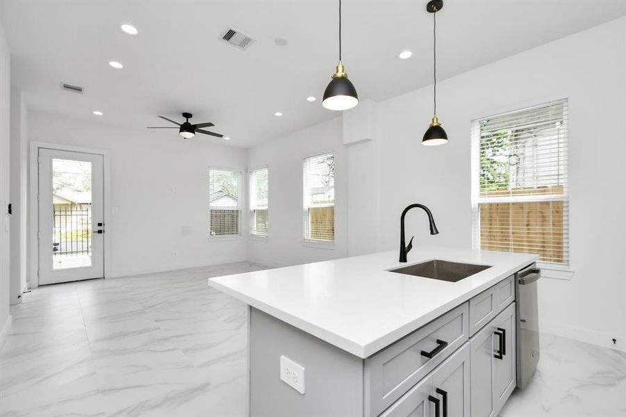 Another view from this well-appointed kitchen into the open living area, offering ample room for comfortably entertaining or relaxing at home with the family.