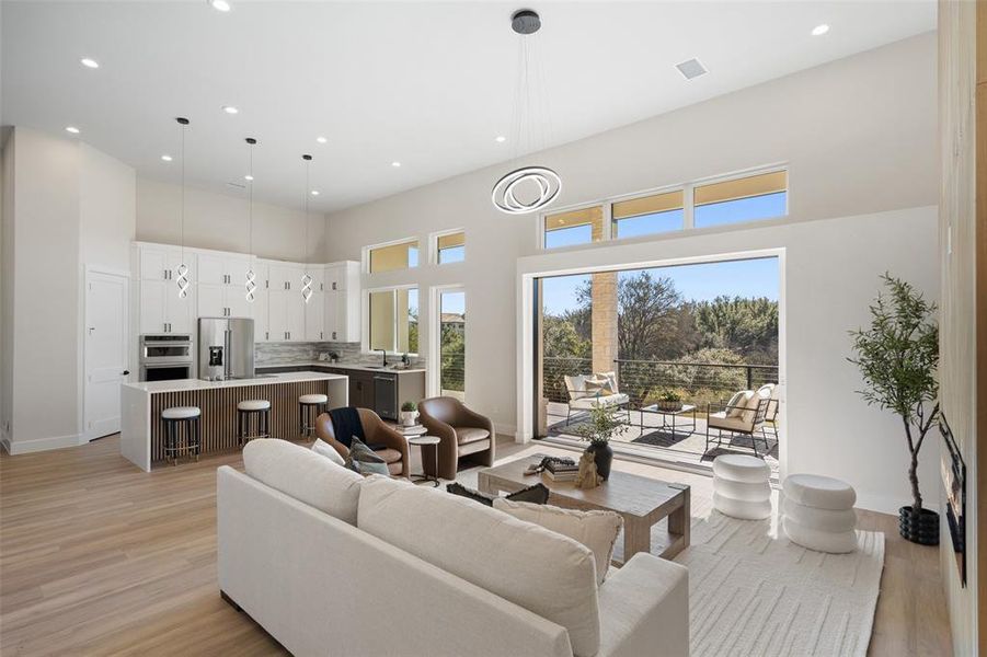 Living area with a towering ceiling, light wood-type flooring, and recessed lighting Living area with a towering ceiling, light wood-type flooring, and recessed lighting